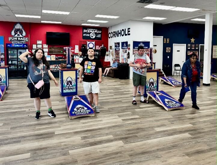 Participants playing cornhole during an outing