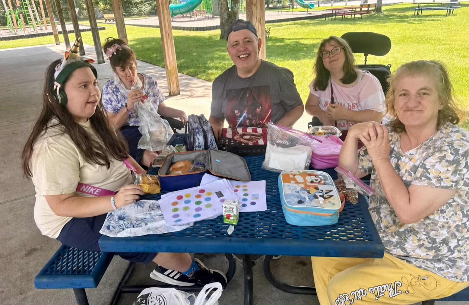 Participants and staff enjoying a picnic together in the park